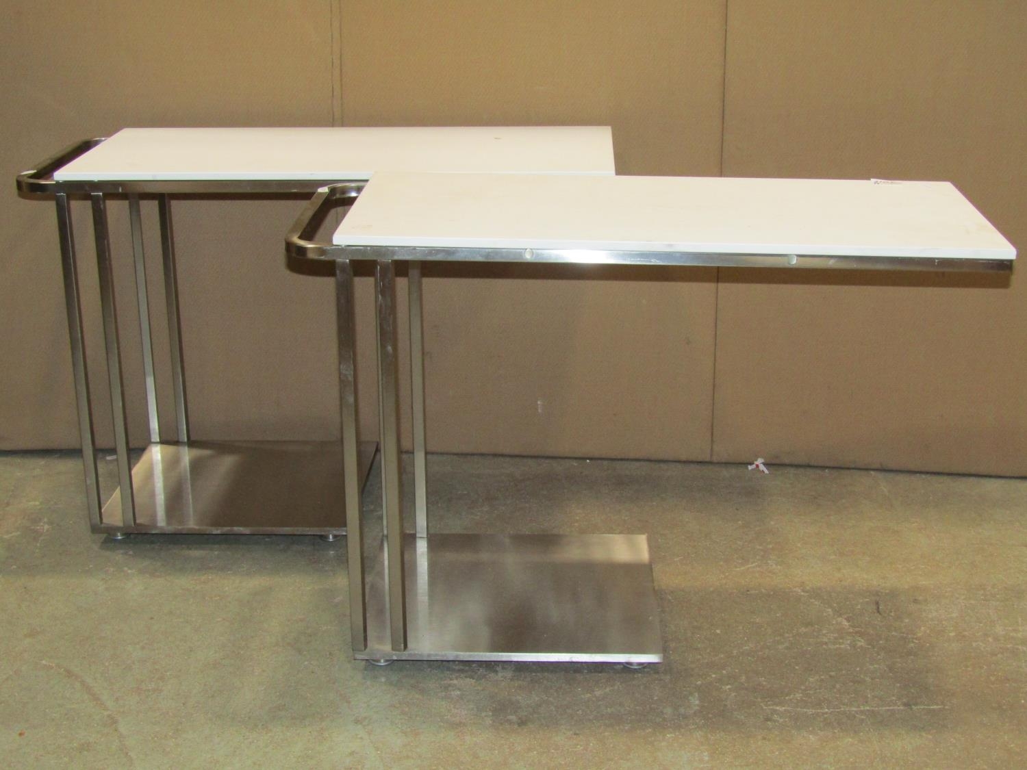 A pair of contemporary chrome cantilever tables with detachable tops