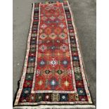An old Persian designed runner with repeating geometric pattern to a central panel, 300cm x 95cm