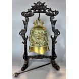 A Chinese brass gong with carved dragon detail, hung from a hardwood stand, with striker, 38cm high.