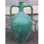 A vintage green painted bottle jar with moulded loop handles and simple incised banded detail,