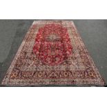 A good quality Central Persian Kashan Carpet, with a central floral medallion on a red ground with