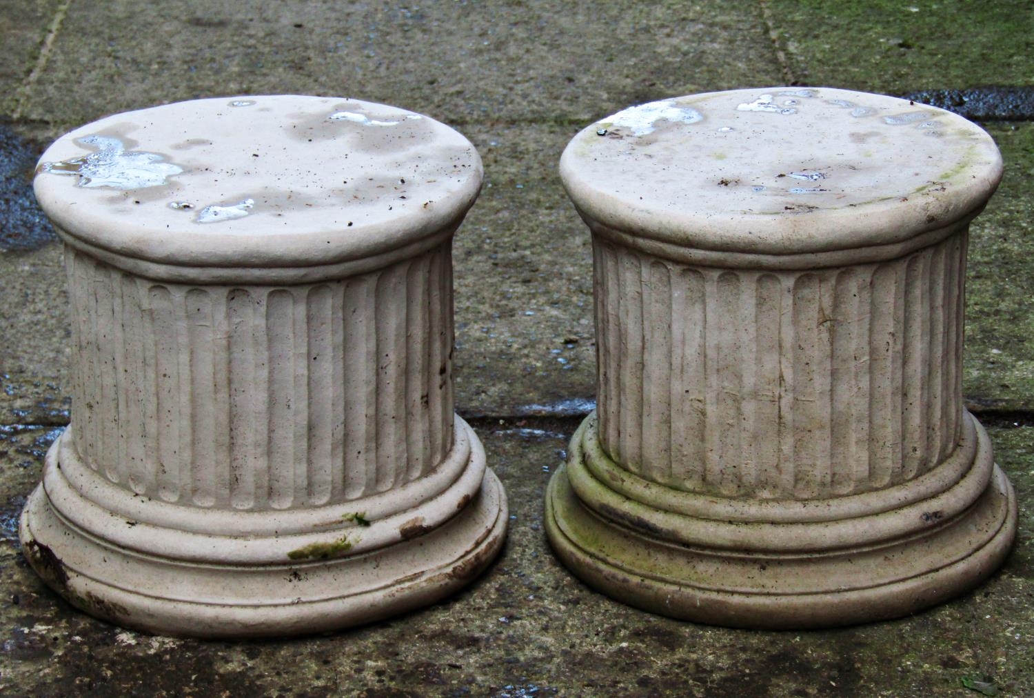 A pair of cast composition stone pedestals of squat cylindrical fluted form, the tops 23cm