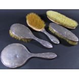 A set of five silver backed hand mirror and brush set