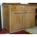 A 19th century stripped pine kitchen side cupboard enclosed by a pair of moulded panelled doors
