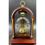 A contemporary skeleton clock, in an arched mahogany coloured and brass inlaid case