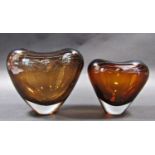 Two amber glass heart shaped vases by Lutken Holmegaard. 16cm and 14cm tall.