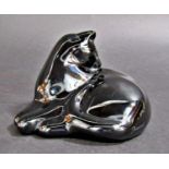 A black Baccarat glass cat grooming itself, signed to the base, 12cm wide approx.