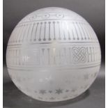 A spherical opaque glass light shade with engraved stars and geometric patterns, 30cm diam approx