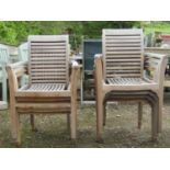 A set of seven weathered teak garden open armchairs with slatted seats and backs