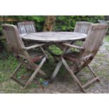 A weathered teak circular folding garden table with slatted top, 125 cm diameter together with a set