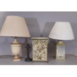 Three table lamps, a single urn shaped lamp, a square lamp with a classical scene, and small