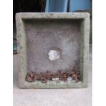 A weathered natural stone trough of rectangular form with square central drain 72 cm x 66 cm x 23 cm