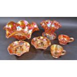 An orange Carnival Glass fruit bowl with scalloped sides, a similar shall vase, , two small dishes