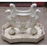 A cast iron boot scraper in the form of a pair of entwined griffins raised on a shaped tray base