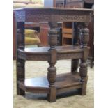 An old English style oak three tier buffet with canted corners and with plaster shaped supports