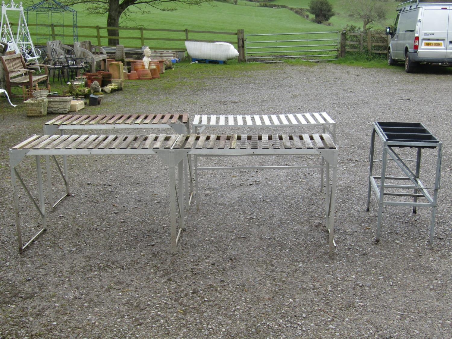 Four aluminium greenhouse potting tables of varying size and design, two with wooden open slatted