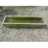 A weathered rectangular carved natural stone trough 112 cm long x 30 cm wide x 20 cm high