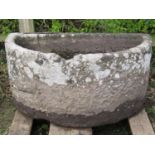 A good weathered thick walled D shaped natural stone trough (af old repair), 112 cm wide x 68 cm