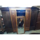 A large Edwardian breakfront mahogany wardrobe, the central mirror panelled door flanked by two