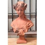 A terracotta bust of a young female in an arts and crafts style