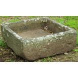 A shallow weathered natural stone trough approximately 50 cm square x 18 cm high