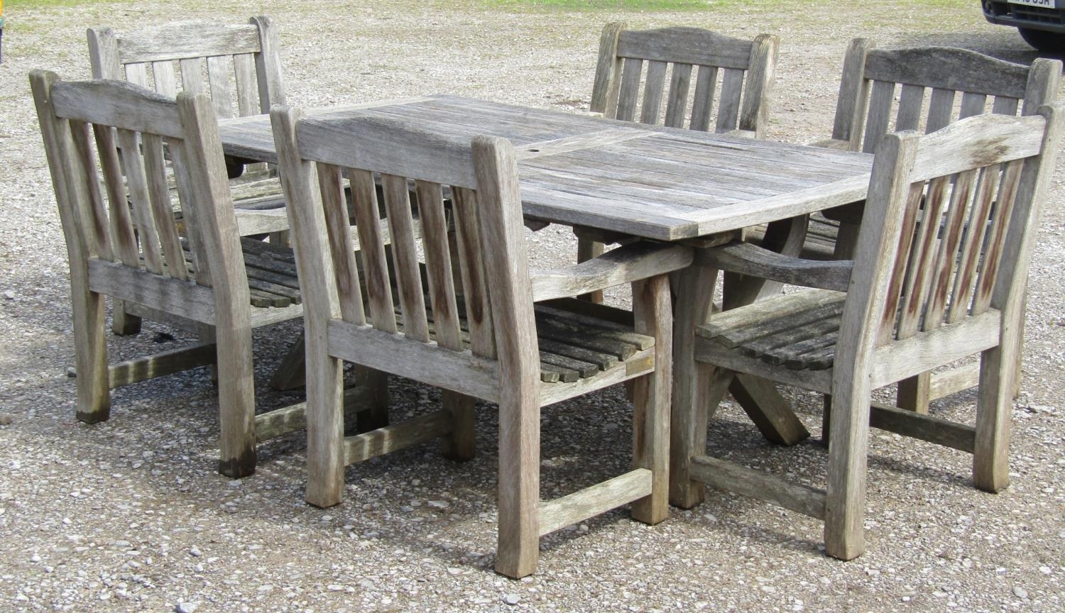 A Woodfurn heavy gauge weathered teak garden table with rectangular overhanging slatted panelled top