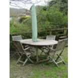 A weathered teak D end extending garden table with single bi-folding leaf raised on square cut