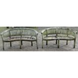 A pair of weathered teak banana shaped garden benches (af) 158 cm wide