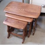 A nest of three Ercol elm occasional tables on shaped and pierced supports, 57cm long and smaller