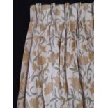One pair of curtains in pale yellow/ green woven floral pattern, lined with triple pleat heading.