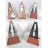 Five metronomes of varying age and make.