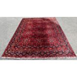 A Turkoman type carpet with an all over geometric pattern on a predominantly red ground, 280cm x