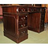 A reproduction Georgian style mahogany veneered kneehole twin pedestal writing desk with inset green