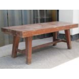 A low pig type bench in heavy dense hardwood, the thick rectangular top raised on square tapered and