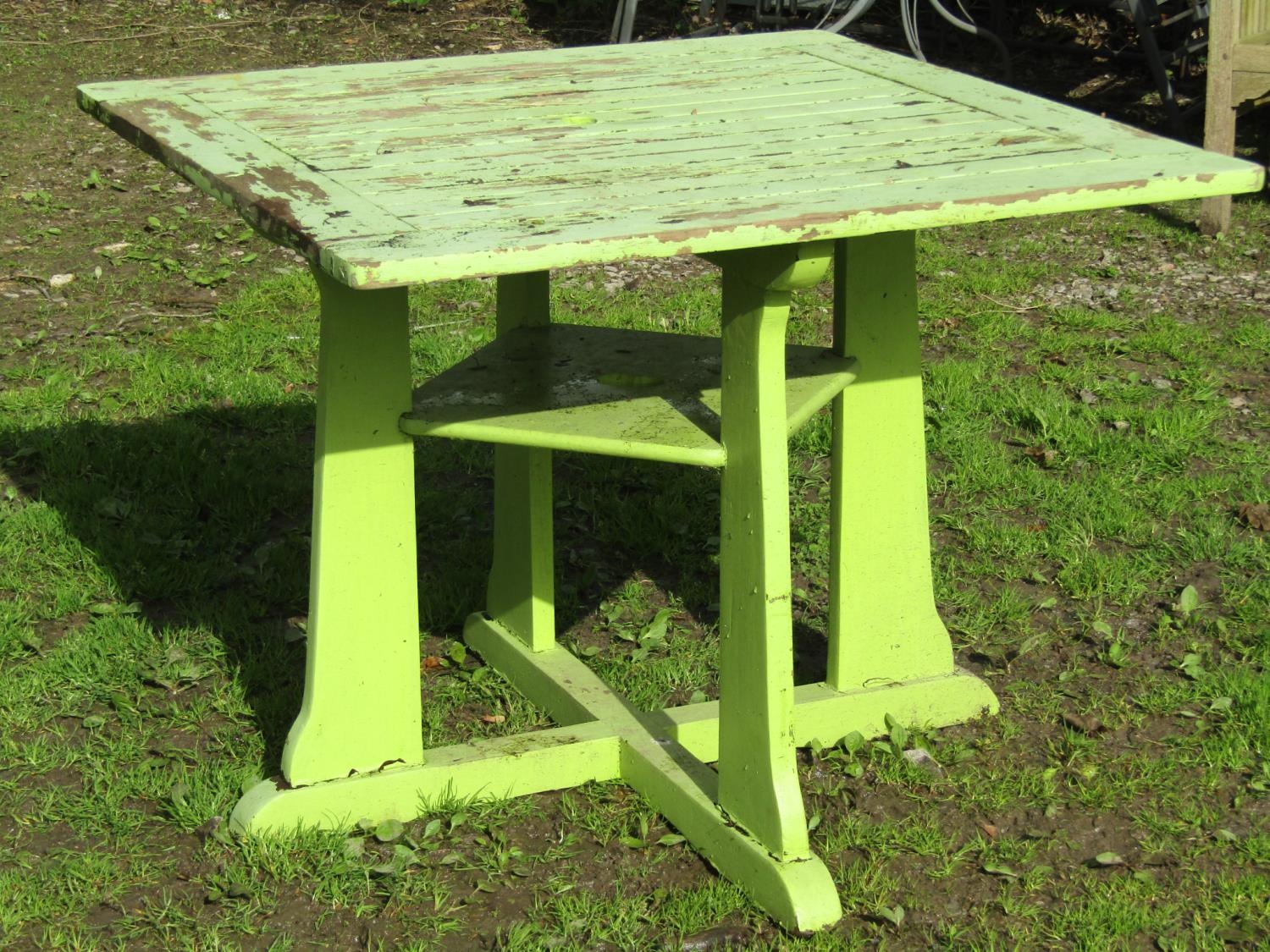 An Arts & Crafts style light green painted and weathered teak garden table, the square slatted