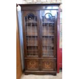 An Edwardian oak library bookcase enclosed by two leaded light doors over two panelled doors 100