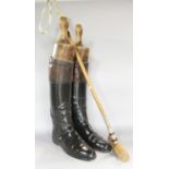 A pair of vintage black and brown leather riding boots, together with original wooden boot trees,