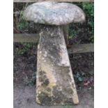 A weathered natural stone staddle stone and possibly associated domed cap 95 cm high approximately .