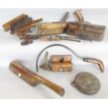 A collection of old vintage wood working tools, including a planes, saw, measures, a patter, hook