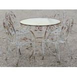 A weathered iron work garden terrace suite comprising circular inset glass top table 92 cm