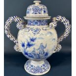 A substantial continental tin glazed urn and cover in a blue and white colourway with hand painted