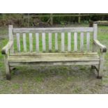A vintage heavy gauge weathered teak garden bench with slatted seat and back (stamped to side rail