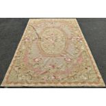 An Aubusson style tapestry wall hanging with a floral medallion and an all over pink rose pattern,