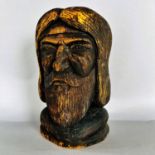A carved and scorched wooden head of a bearded man, 23cm high.