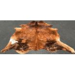 A cow hide rug/covering, branded R, with one small hole, 220cm x 180cm approx.