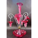 A Victorian cranberry and clear glass epergne with a central trumpet vase surrounded by a further