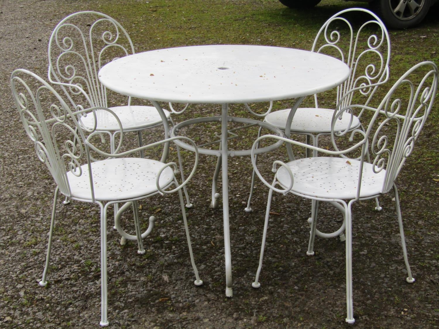 A cream painted metal garden terrace suite comprising circular topped table, 95 cm diameter and a