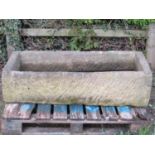 A good weathered thick walled rectangular natural stone trough with corner drainage hole 125 cm long