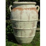 A large ribbed terracotta jar with moulded loop handles and all over painted and distressed