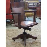 An oak framed office chair with rexine upholstered seat and back on swivel base